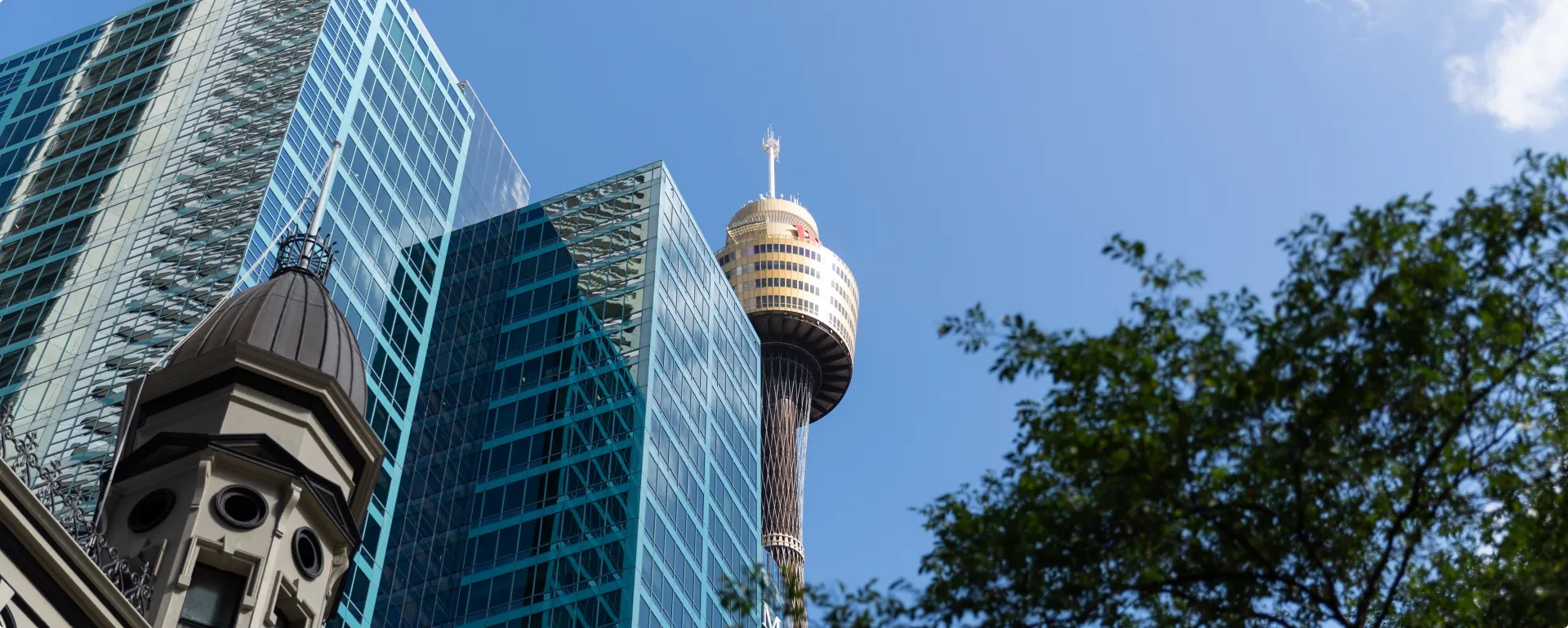 A view of a tall building with a sky scraper in the background.