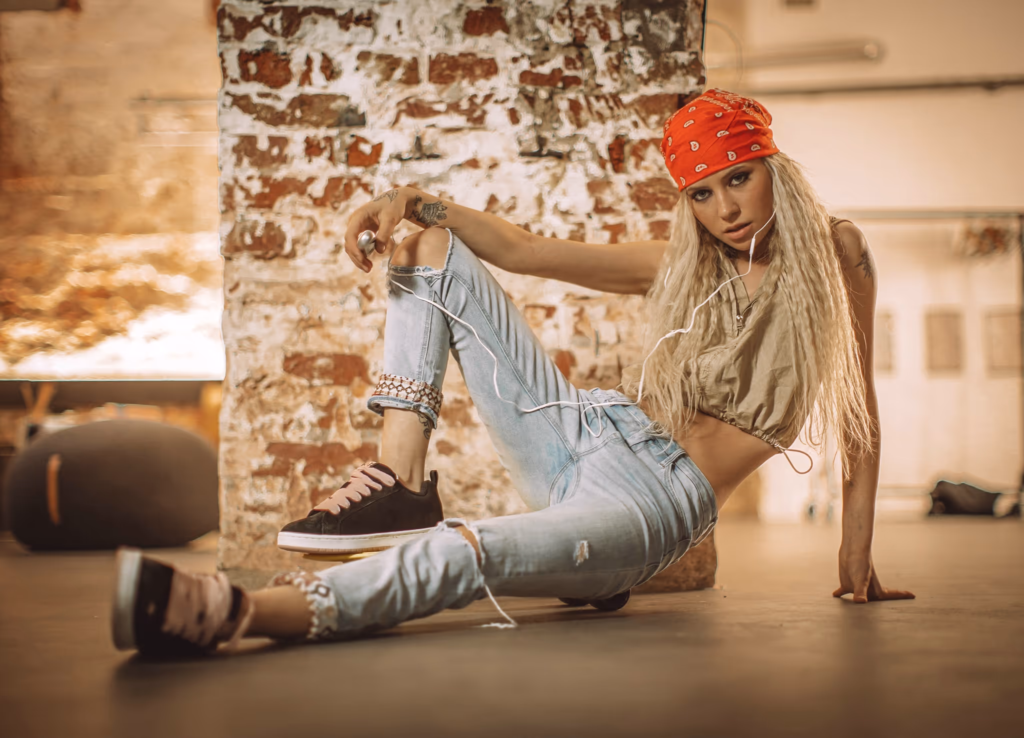 Schwarz-Weiß-Porträt einer jungen Frau mit langen Haaren, die ihre Hände hinter dem Kopf hält und direkt in die Kamera schaut.