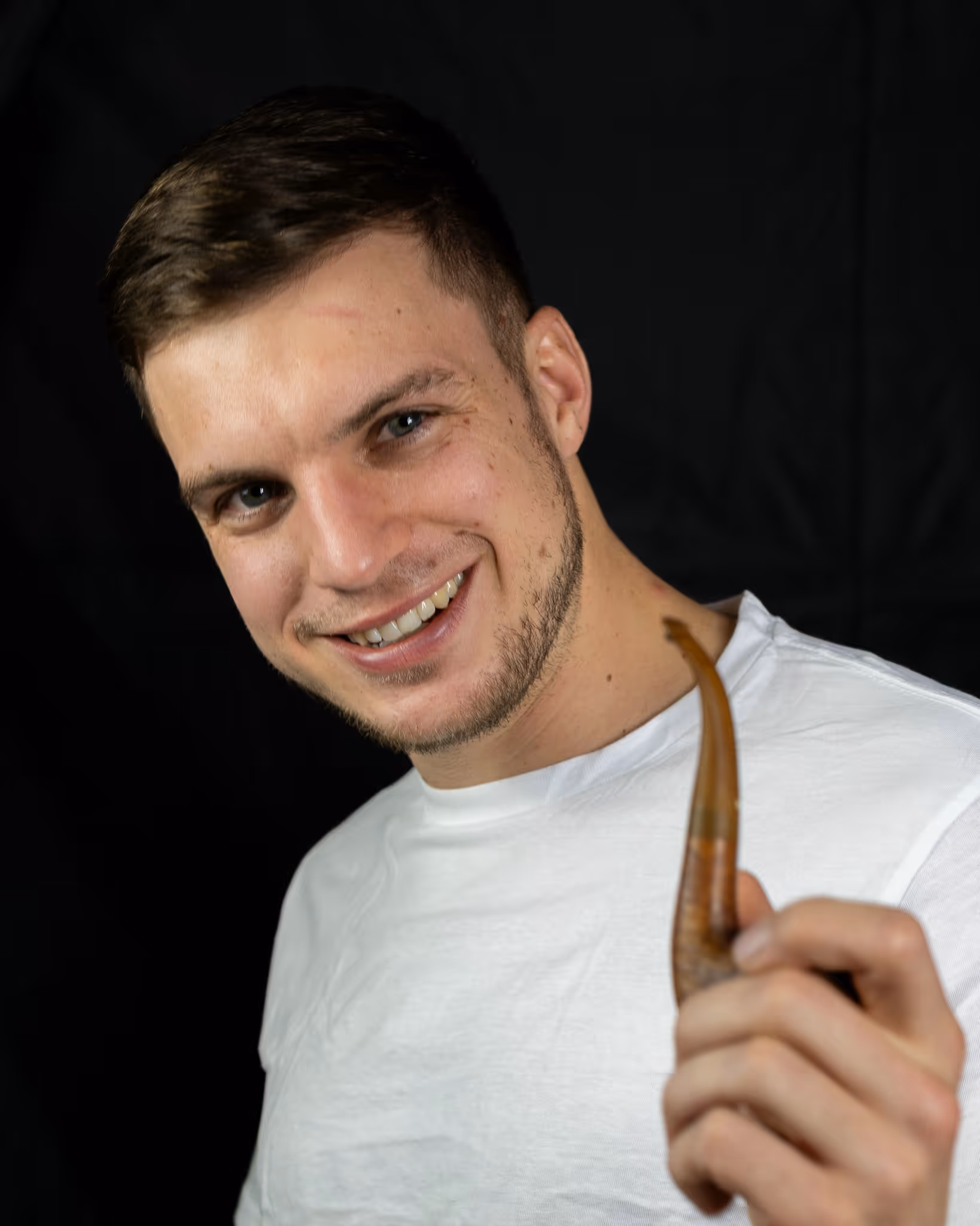 Frau im roten Kleid hält einen bunten Regenbogenschirm und berührt ein Ährenfeld.