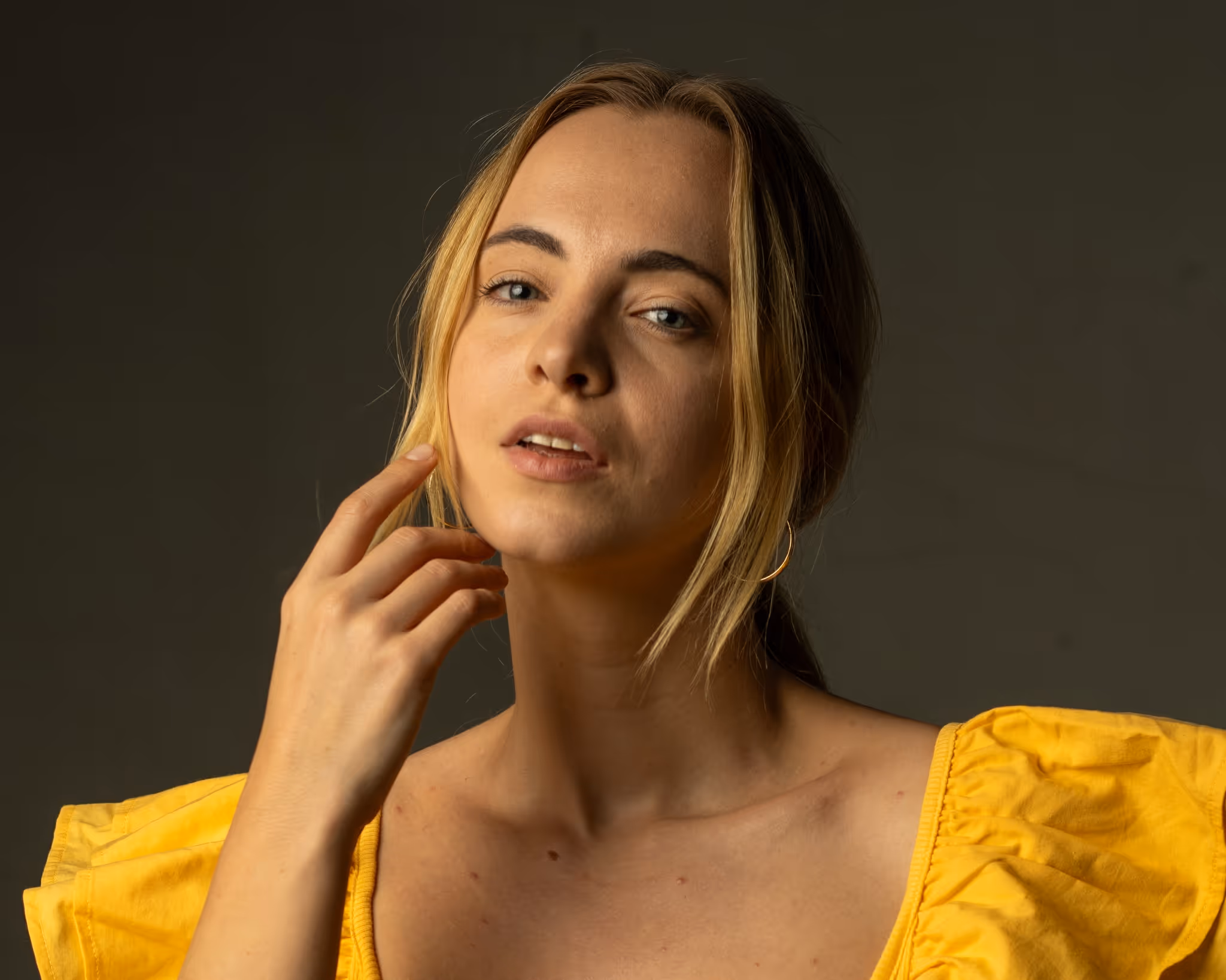 Ein Mann mit Bart, schwarzem T-Shirt und Hut hält eine Flasche in der rechten Hand und einen Gehstock in der linken.