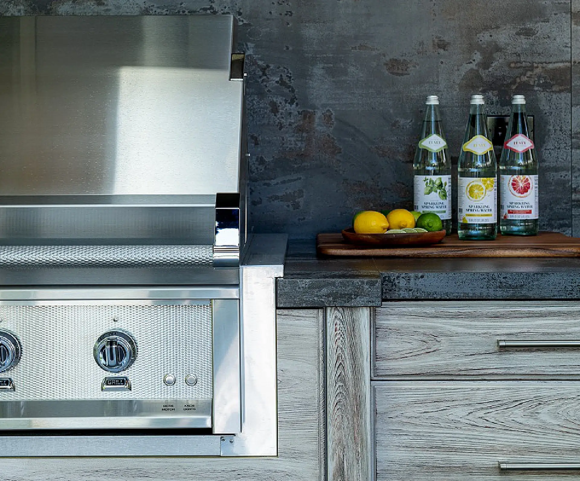 Outdoor grill and wooden countertop topped with lemons and drinks