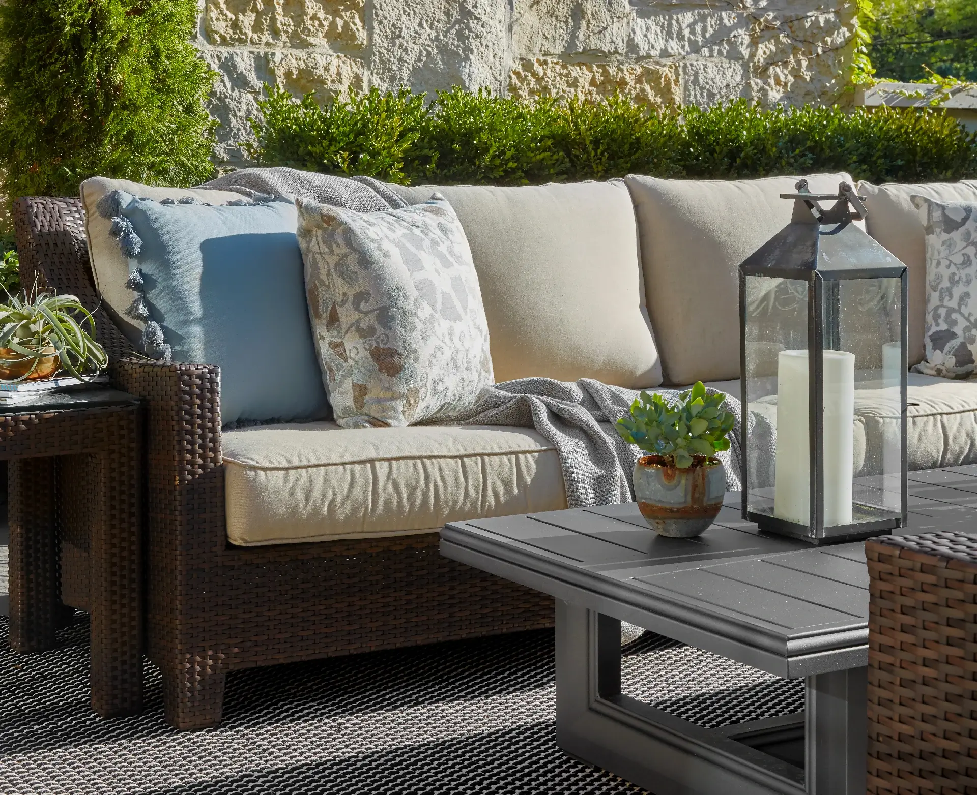 Outdoor couch and coffee table surrounded by lush landscape