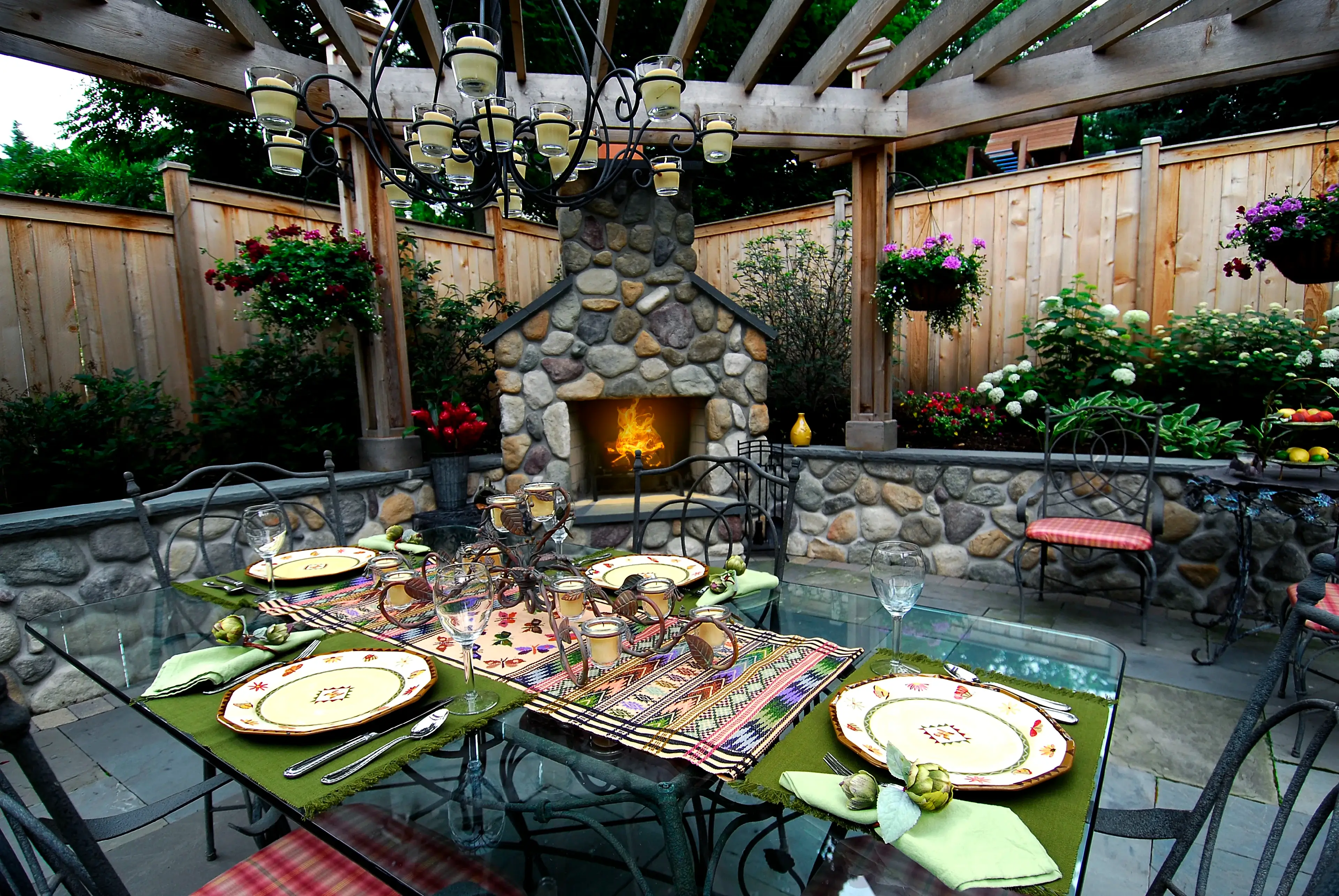 Outdoor dining table centered in front of an outdoor fireplace