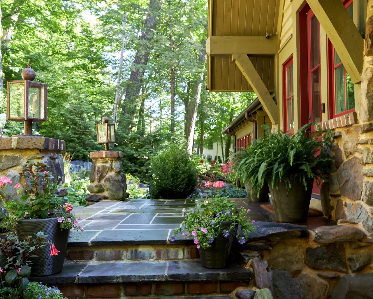 Slate stone back steps leading to house with flower planters on the patio