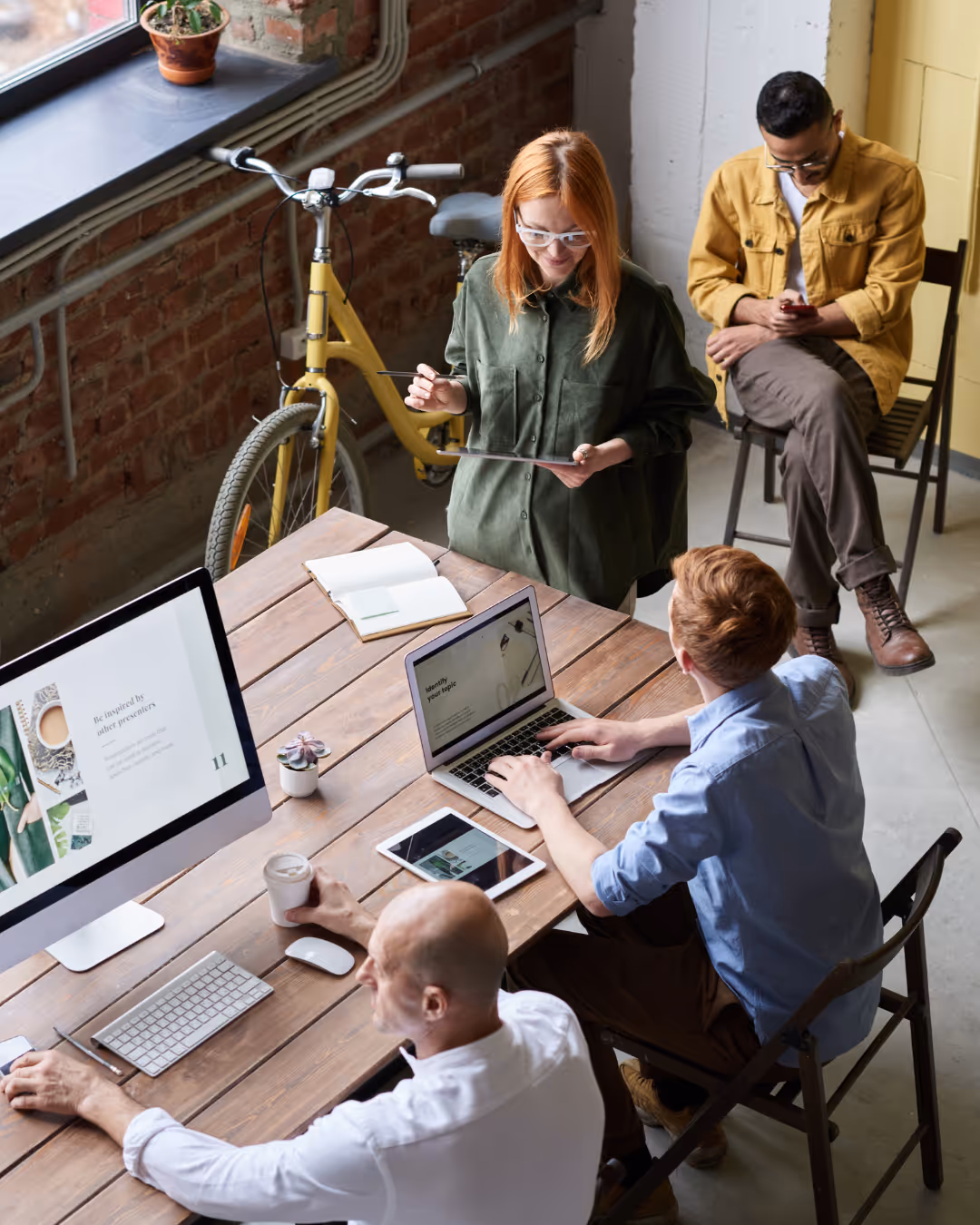 Vier professionals die samenwerken met laptops en een tablet, als illustratie van Webamigo’s webprojecten en digitale oplossingen.