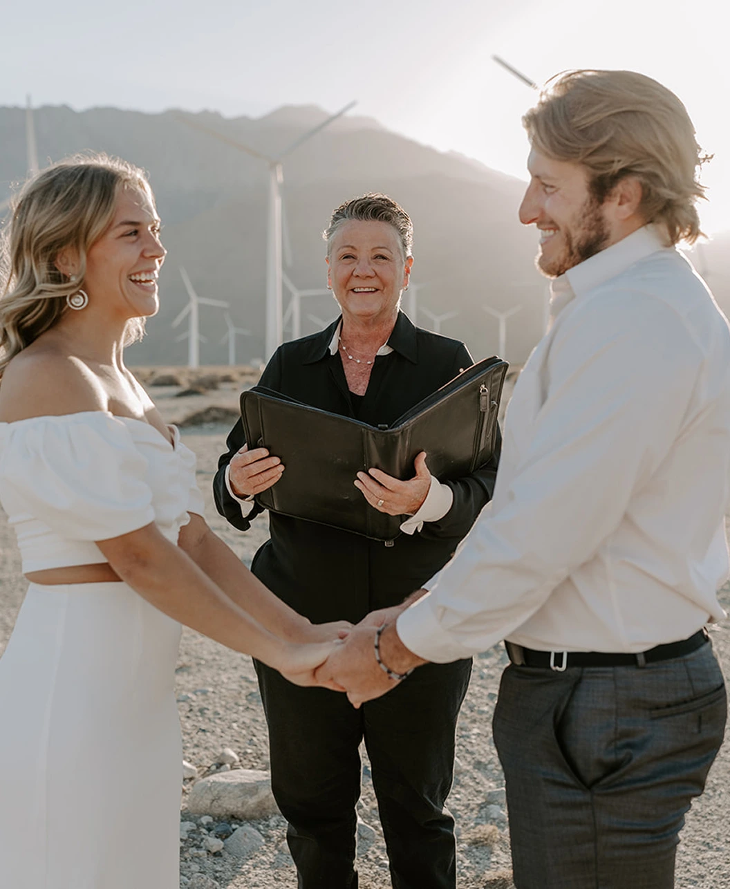 A photo of the couple in front of the officiant on a wedding ceremony