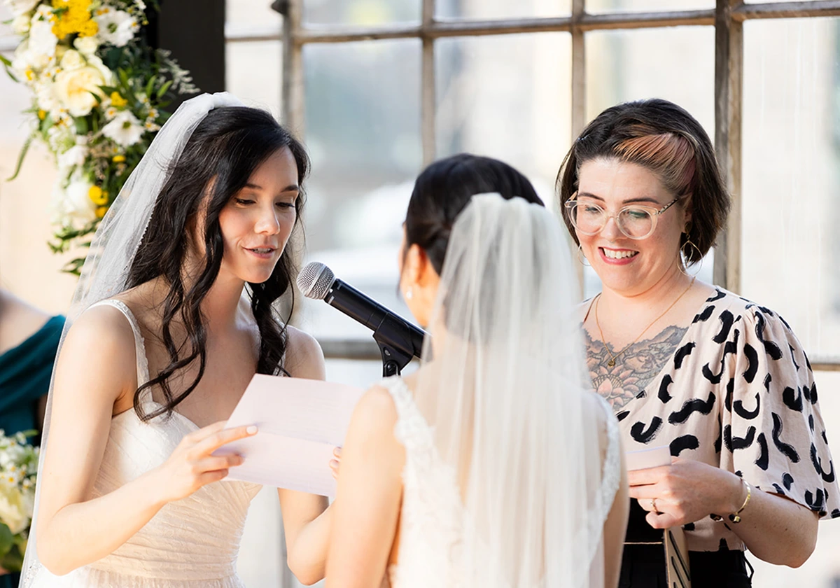 A photo of the couple in front of the officiant on a wedding ceremony