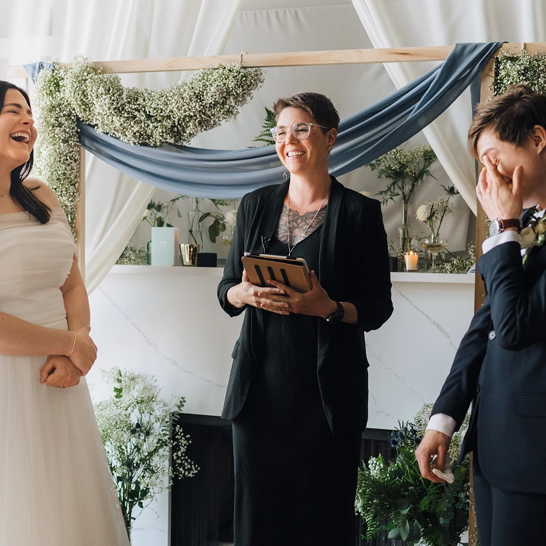 A photo of the couple in front of the officiant on a wedding ceremony
