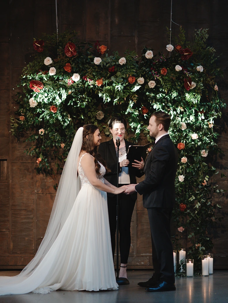 A photo of the couple in front of the officiant on a wedding ceremony