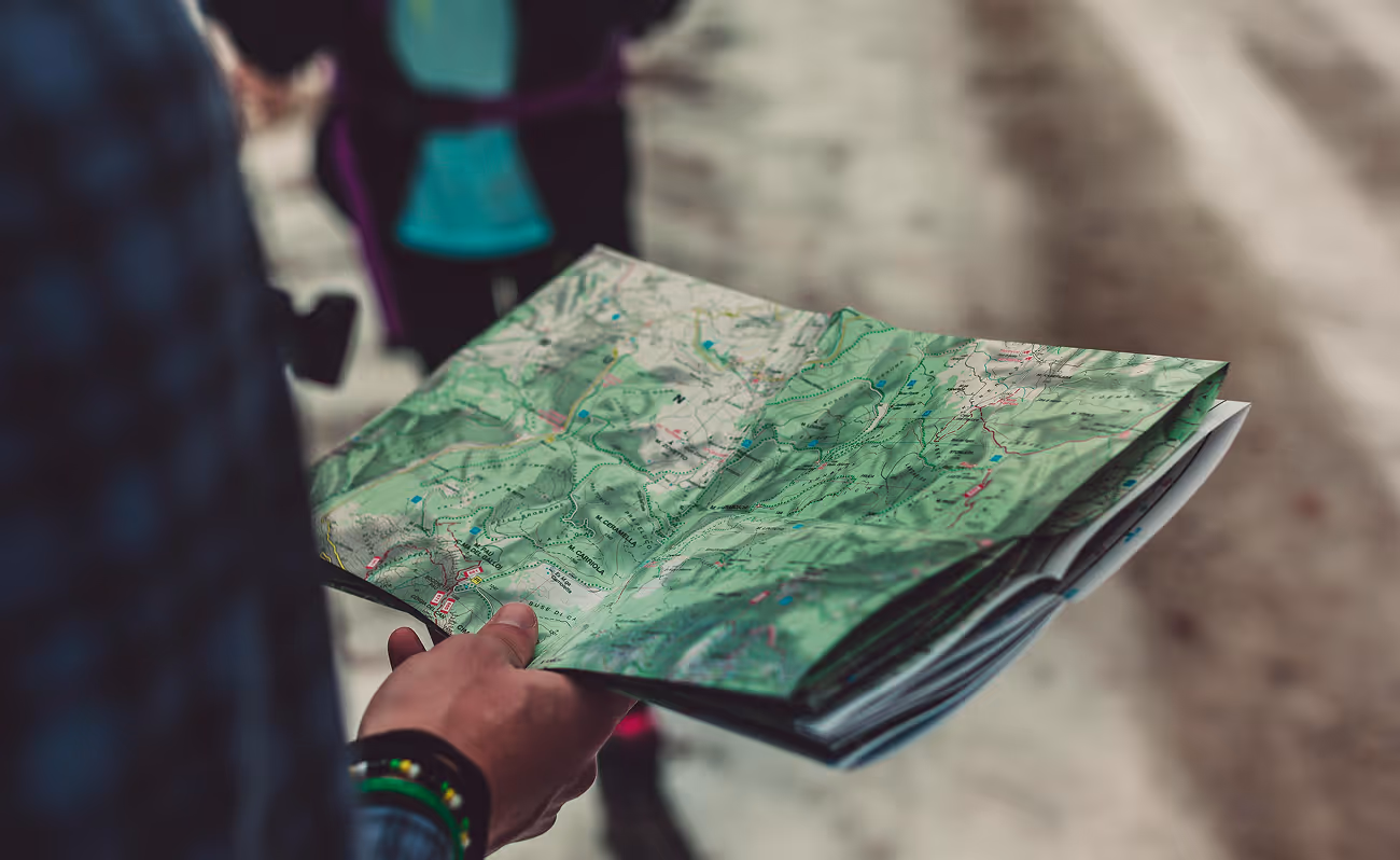 Person holding a map, examining it closely.