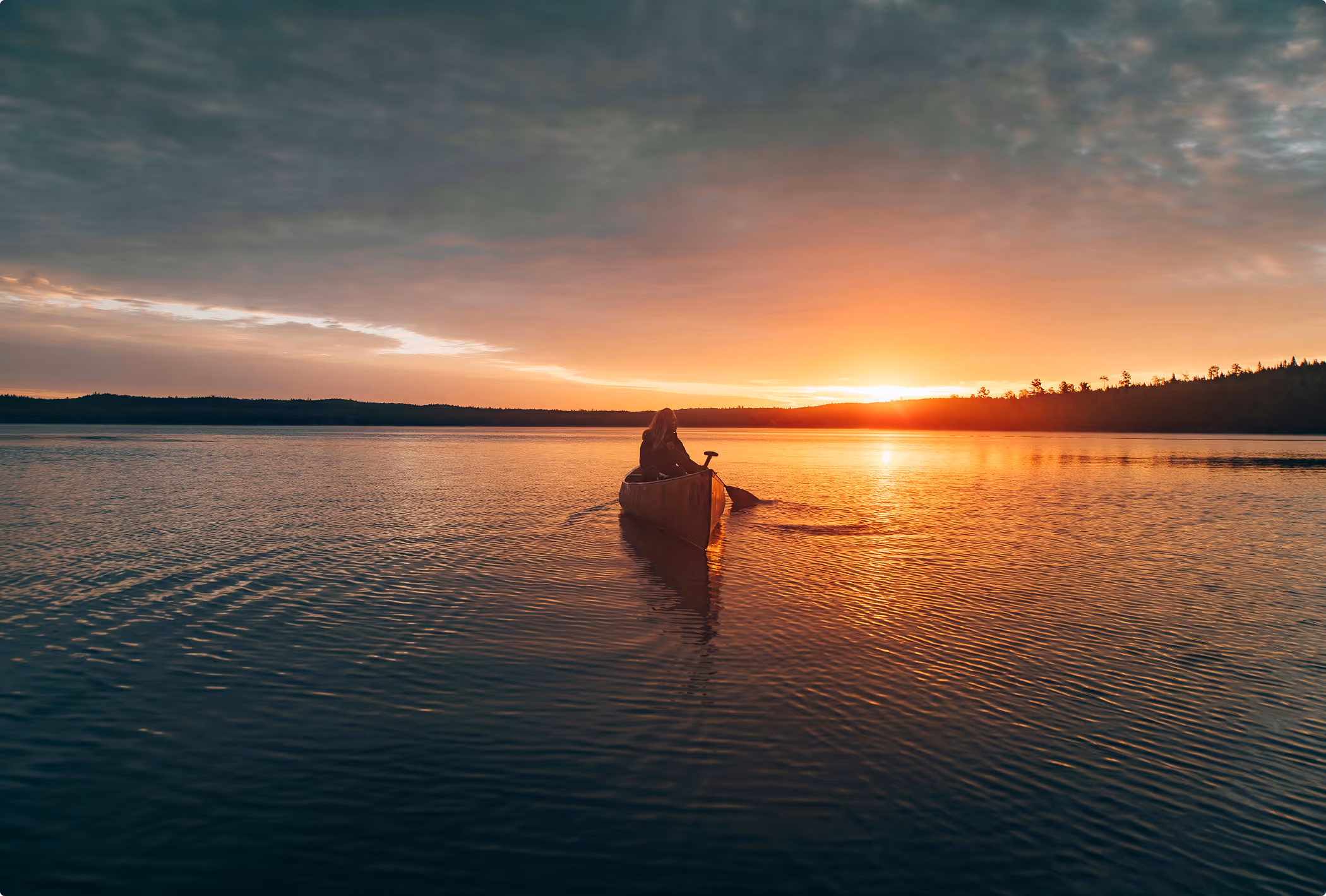 Single canoe resting on a calm lake in the early morning light.