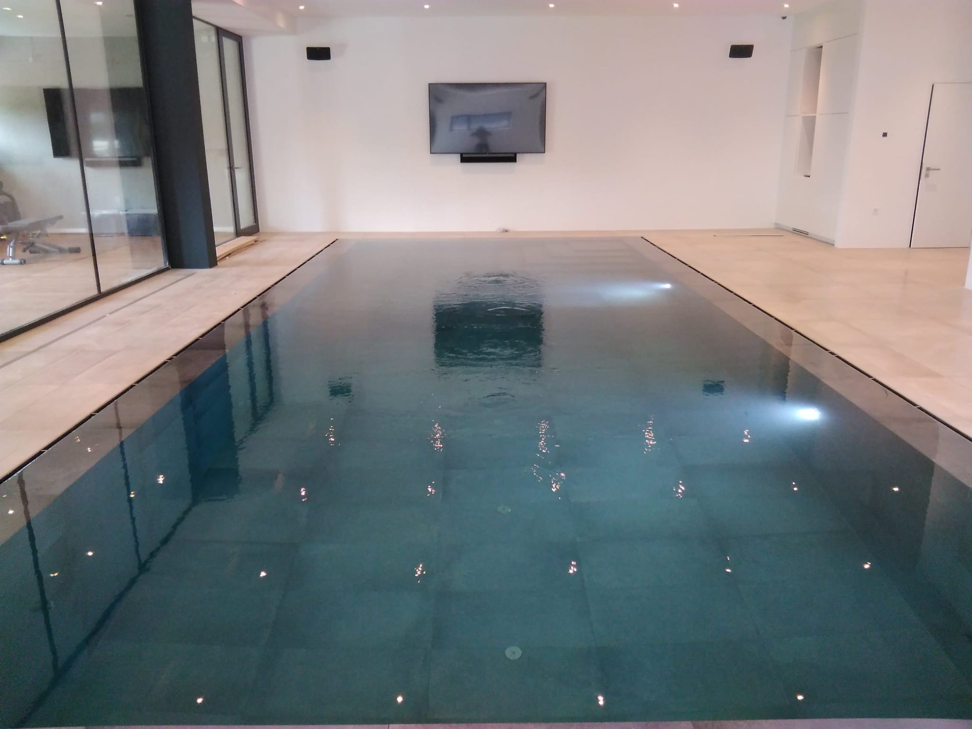 Piscine intérieure à débordement miroir à La Chaux-de-Fonds, réalisée par Espace Piscines et Spas.