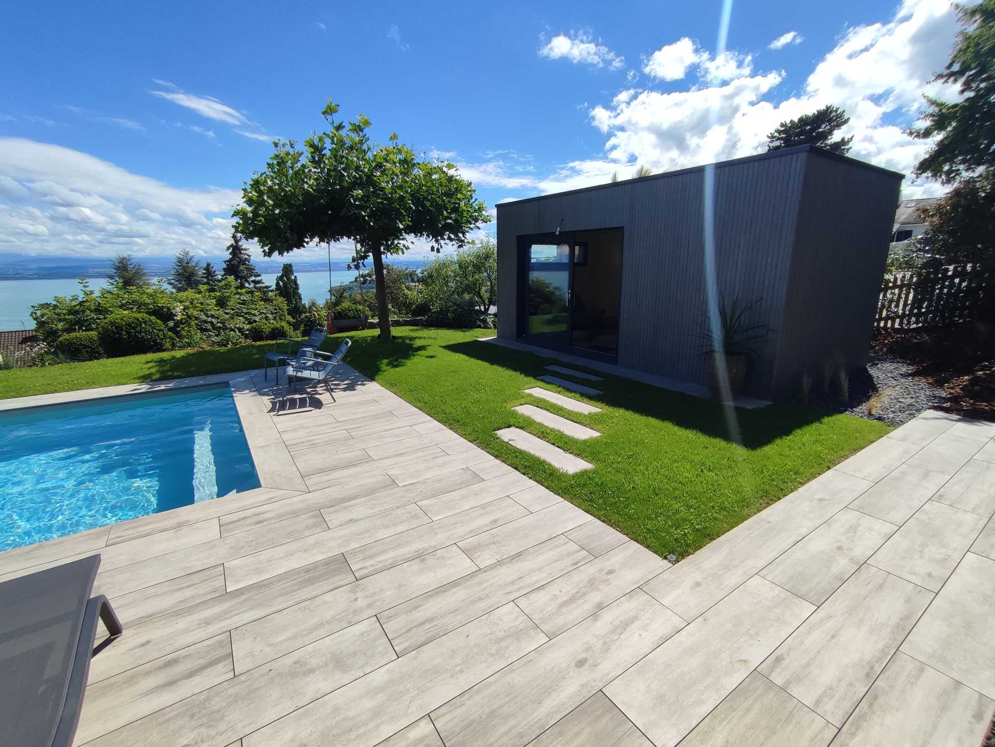 Piscine et poolhouse à Corcelles, réalisés par Espace Piscines et Spas.
