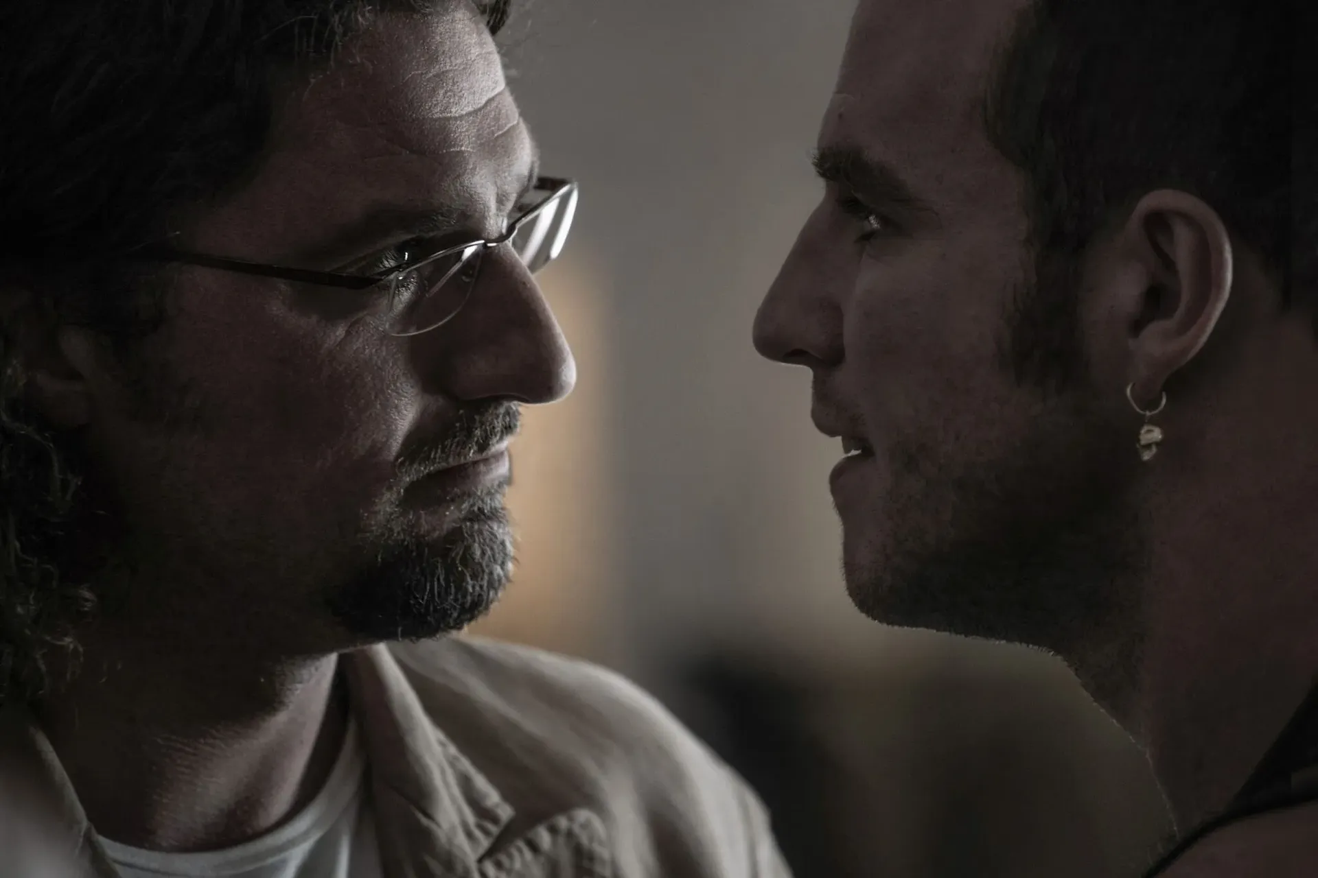 Close up of two men staring each other intensely in the eye, facing off.