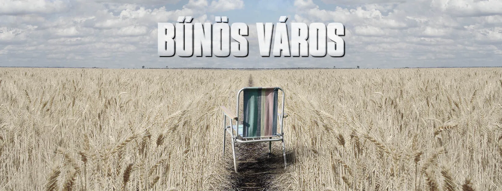 A lone folding chair sits in the middle of a vast wheat field under a cloudy sky, with the bold title Bűnös Város floating above.