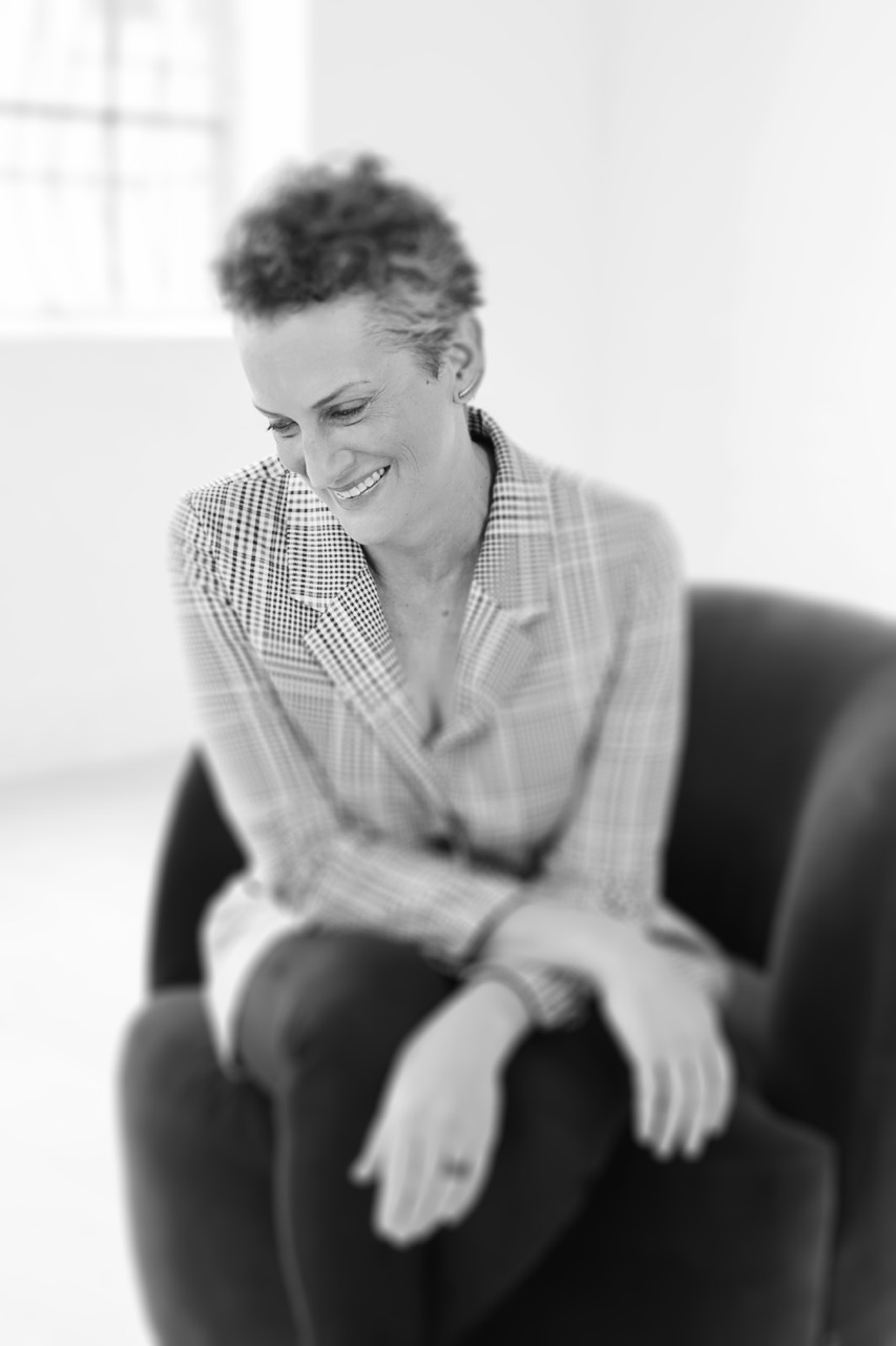 Black and white photo of Tessa smiling while looking down