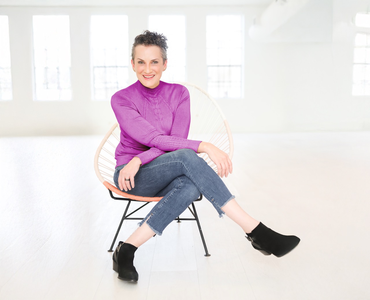 Color image of Tessa in a pink shirt sitting in a chair