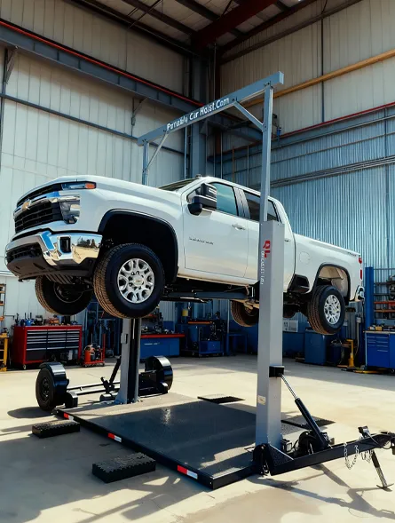 White pickup truck elevated on a portable car hoist inside a garage with tools and equipment.