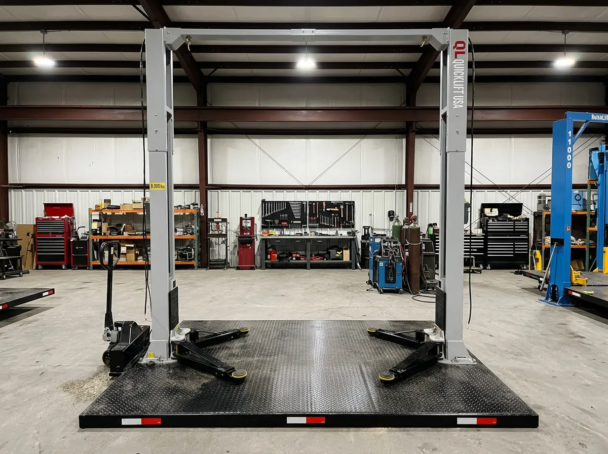 Empty vehicle lift in a clean, organized automotive workshop with tools and equipment in the background.