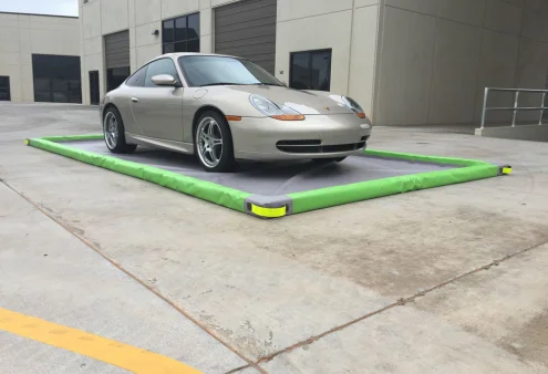 Drive-over spill mat in use beneath equipment during temporary fluid transfer.