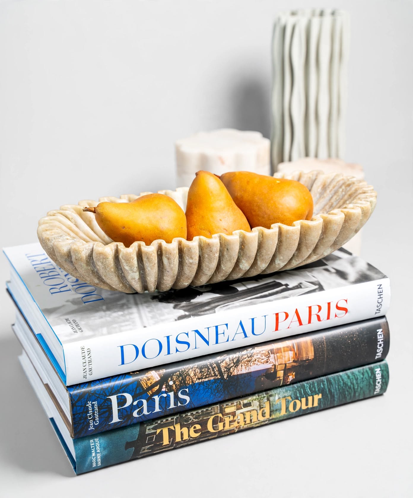 Marble bowl with golden pears on a stack of Paris and Grand Tour coffee table books