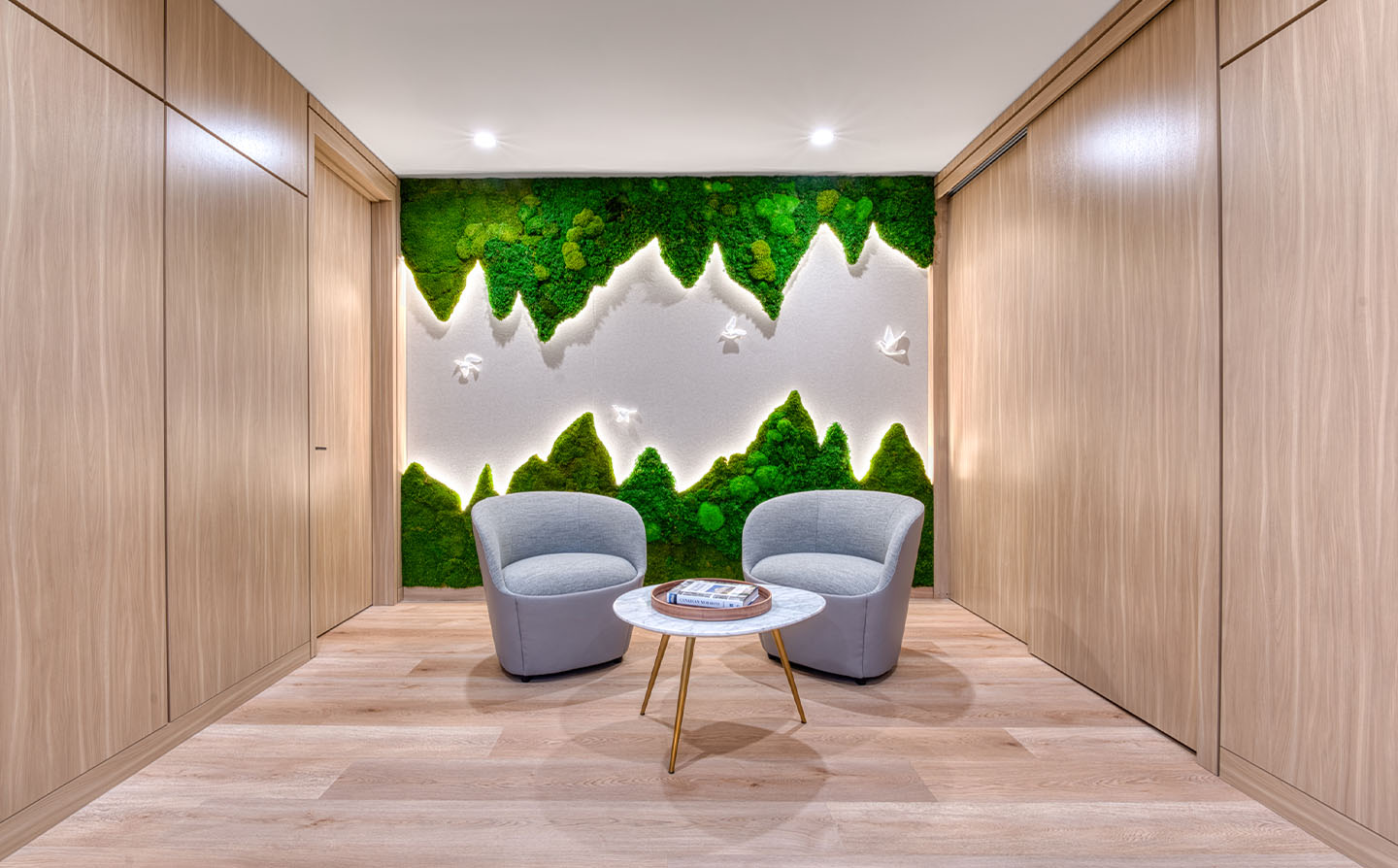  Intimate seating alcove with moss wall installation shaped like mountain peaks and white dove sculptures.