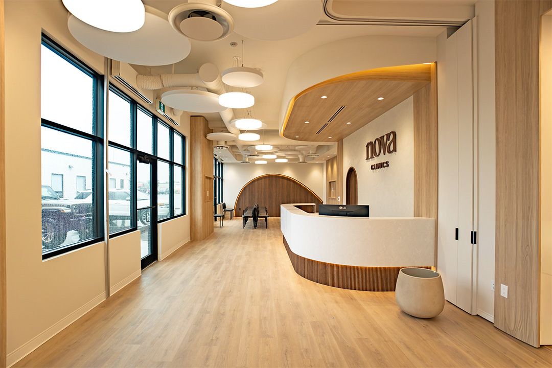 Nova Clinics lobby with curved reception desk, wood canopy ceiling, and floor-to-ceiling windows