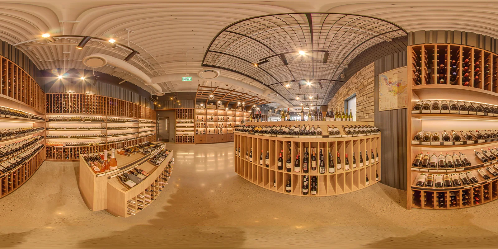 360° panorama of the main wine floor with curved display units, a black grid ceiling feature, a stone wall, and a Bordeaux map on the right.