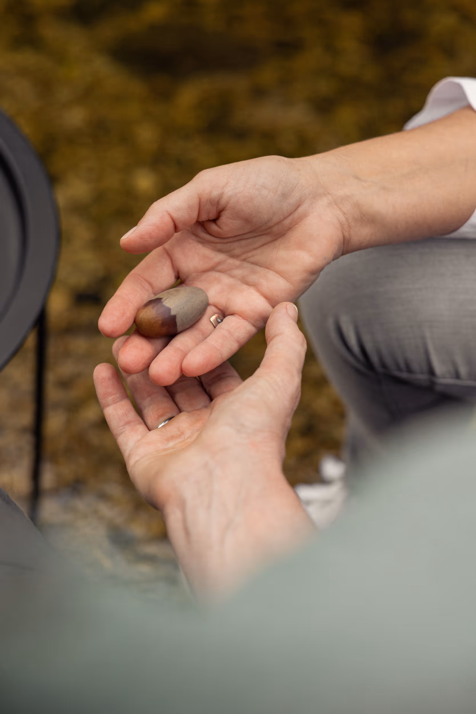 Zwei Hänge liegen übereinander - in einer Hand liegt ein Stein
