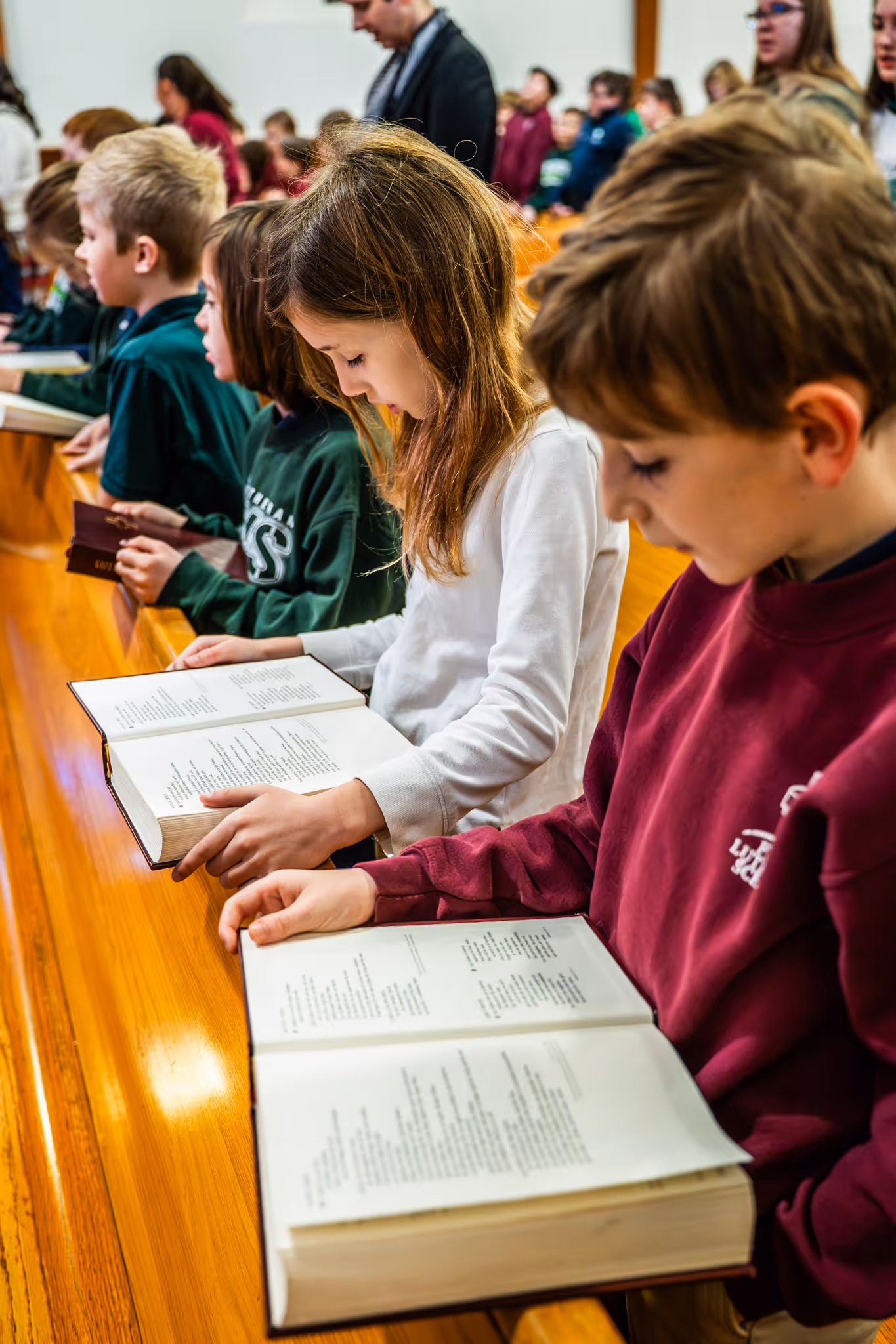 Toddler in daisy-patterned pajamas holding a yellow toy block in a playroom.