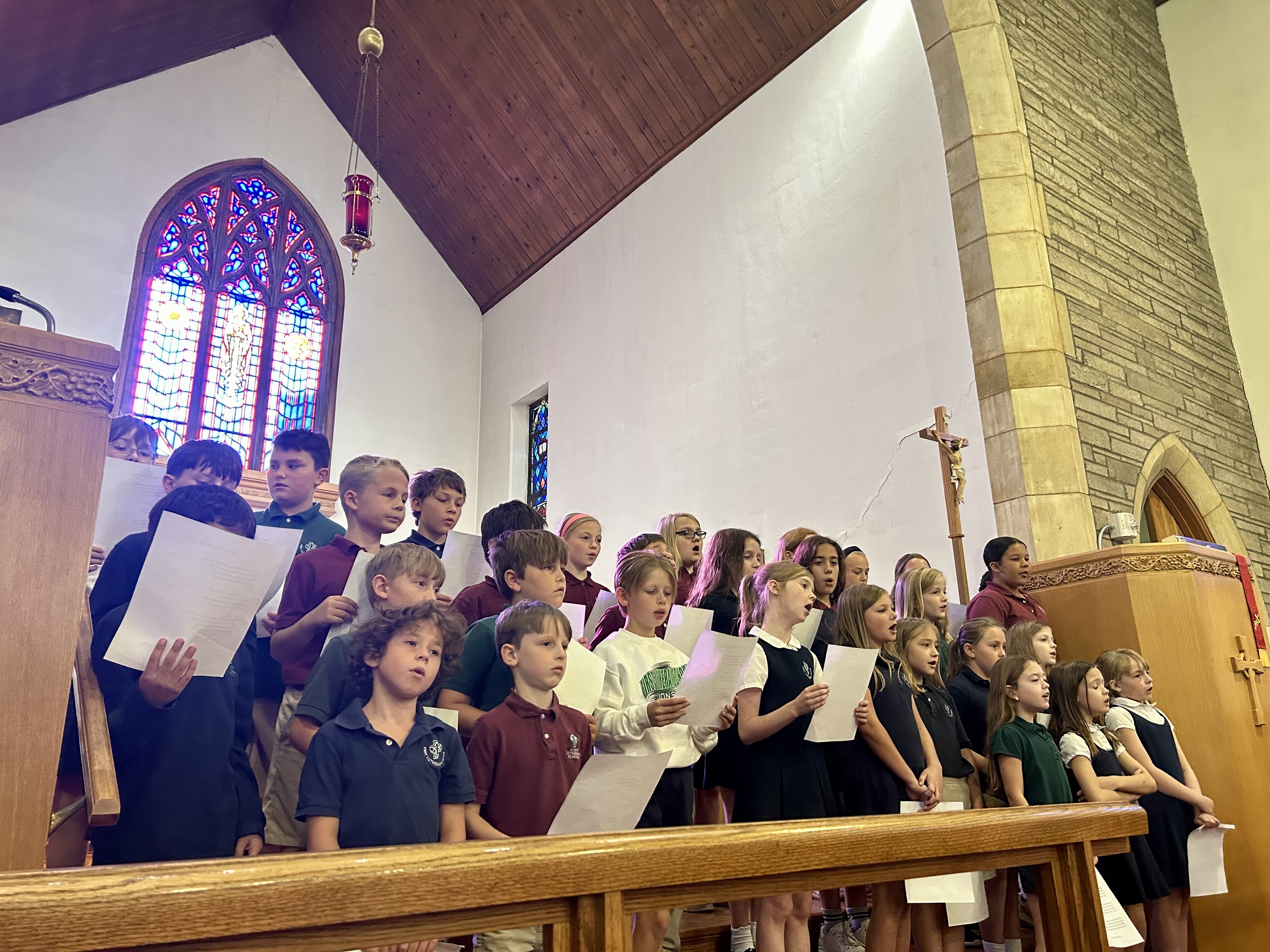 Elementary school students in a classroom building a project using labeled cardboard boxes, one labeled Room B.