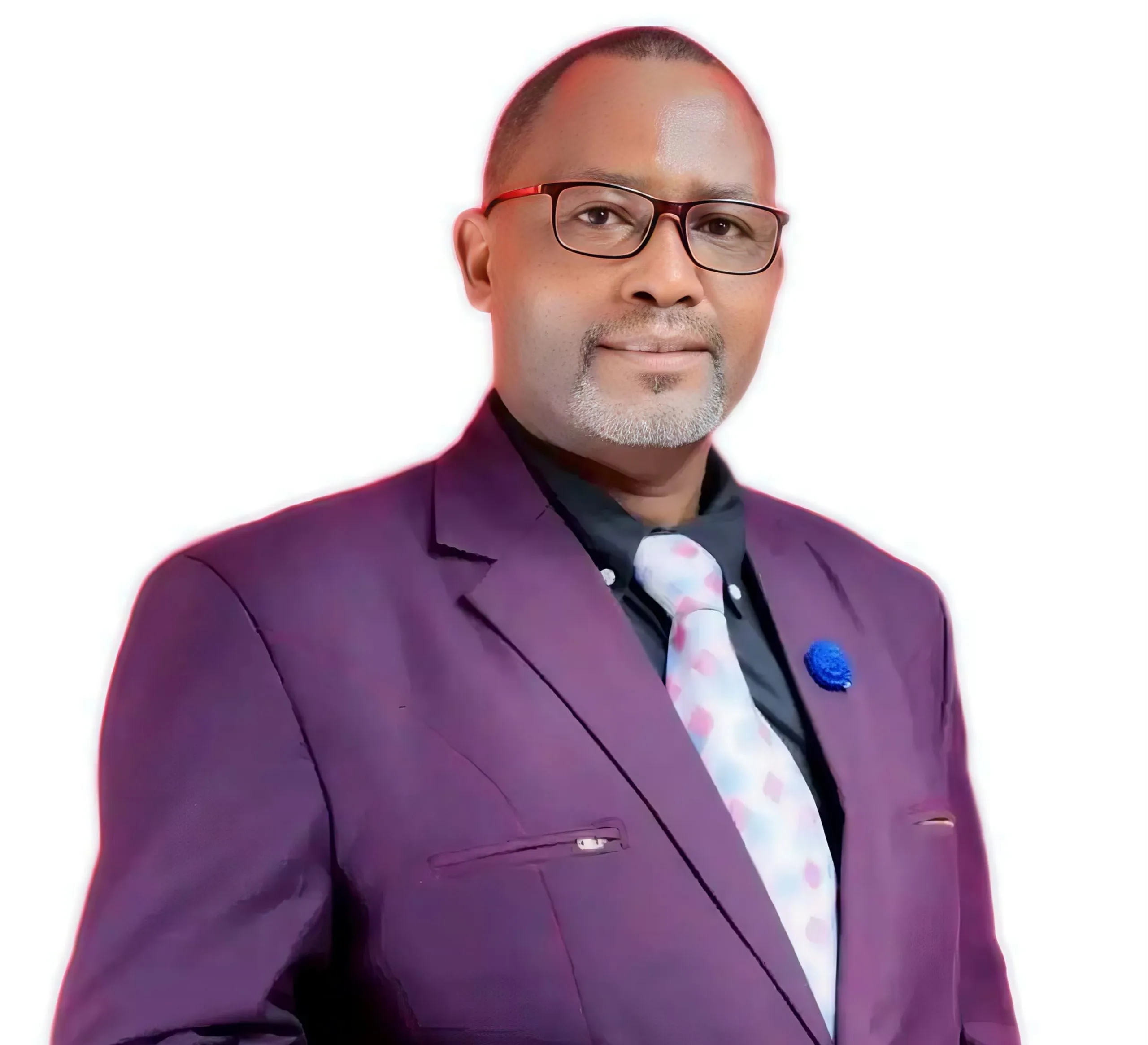 Man with a short beard and glasses wearing a purple suit jacket, black shirt, and light patterned tie.