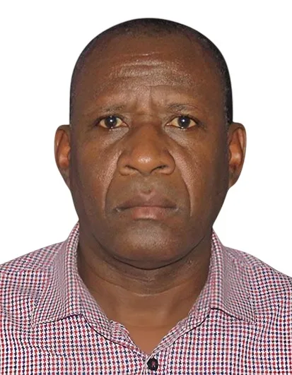 Serious middle-aged man wearing a checkered shirt against a white background.