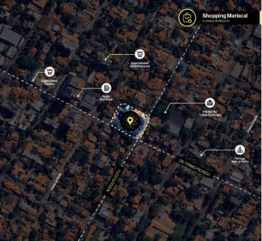 Mapa aéreo que muestra la ubicación de Shopping Mariscal en el centro, con iconos señalando supermercados, bancos y restaurantes cercanos en un barrio con calles delimitadas.