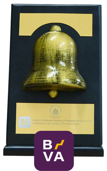 Campana dorada sobre un soporte negro con una placa que celebra el nuevo logo de la Bolsa de Valores y Productos de Asunción.