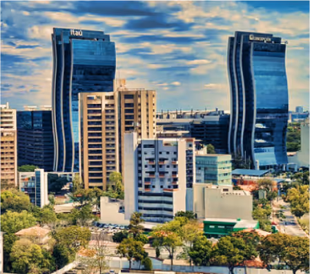 Vista urbana con edificios modernos y árboles, con las torres curvas de Itaú y la Torre del Banco Continental al fondo.