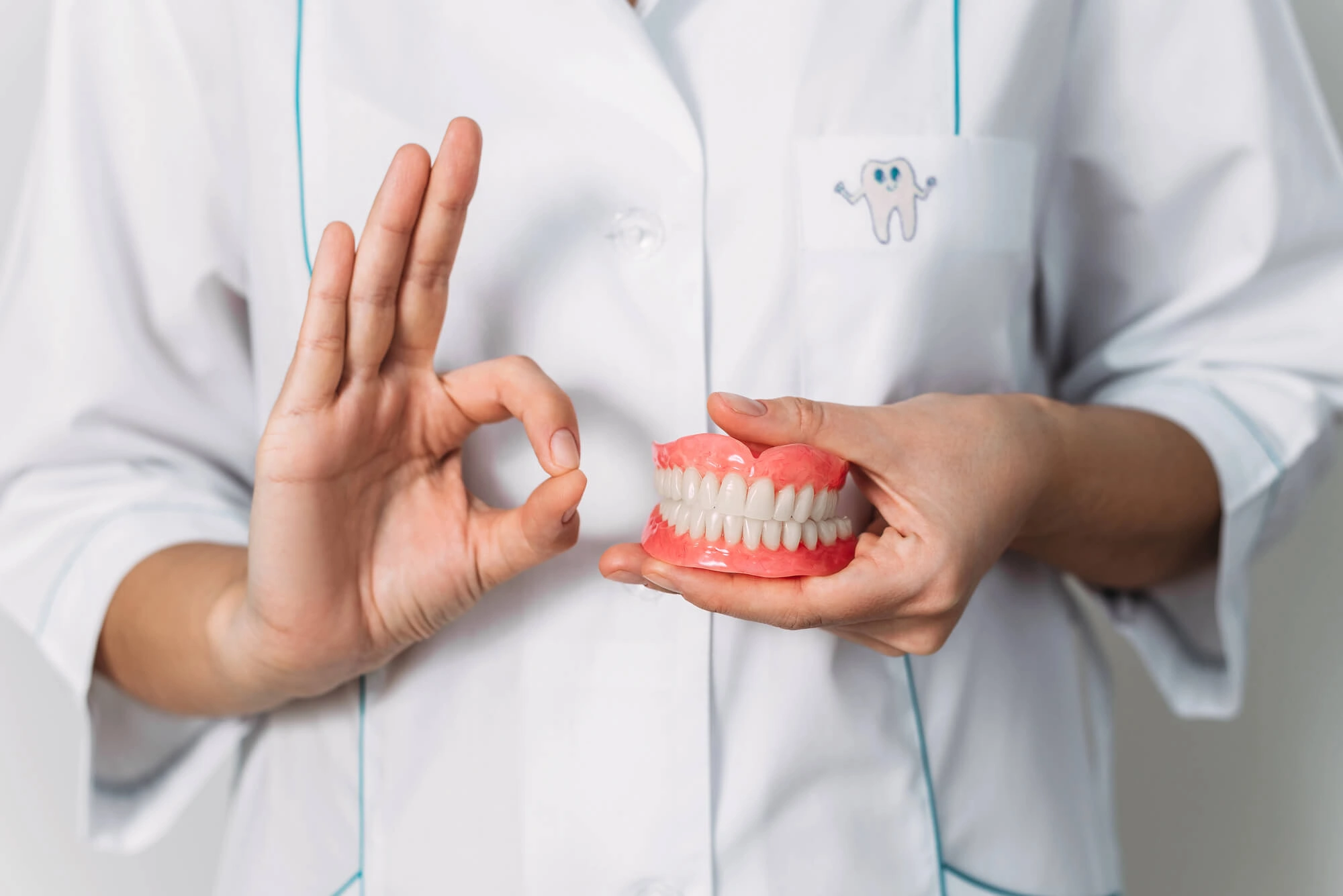 Dentist holding dentures opelika