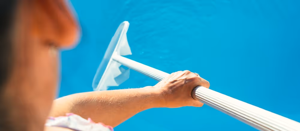 person cleaning pool