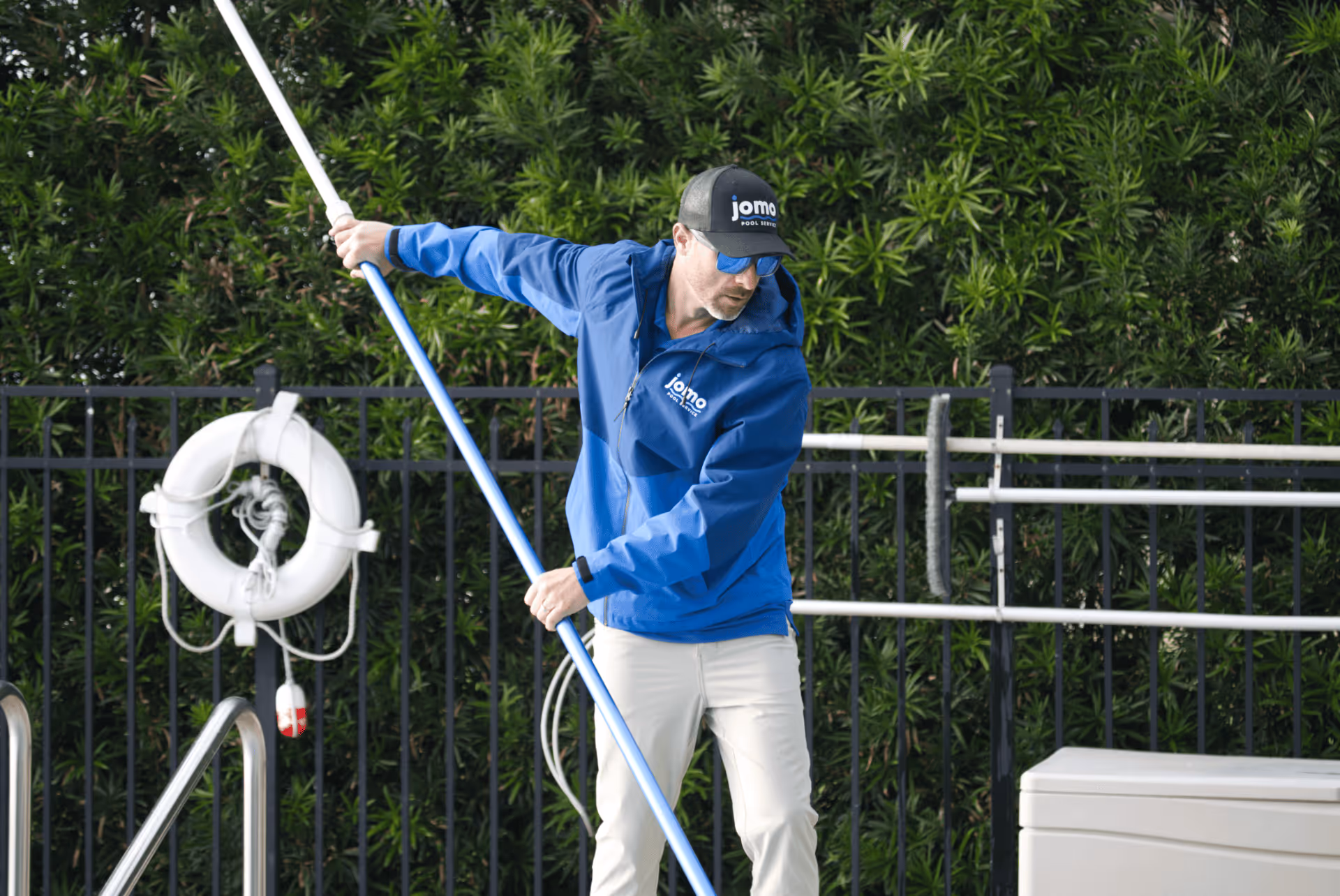 jomo pool service employee cleaning pool in florida