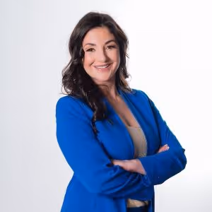 Pamela Garrett in a blue suit smiling with her arms crossed