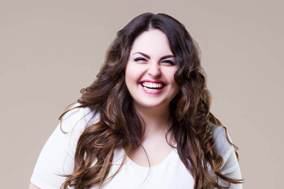 smiling woman with long brown hair and white shirt posing for a picture