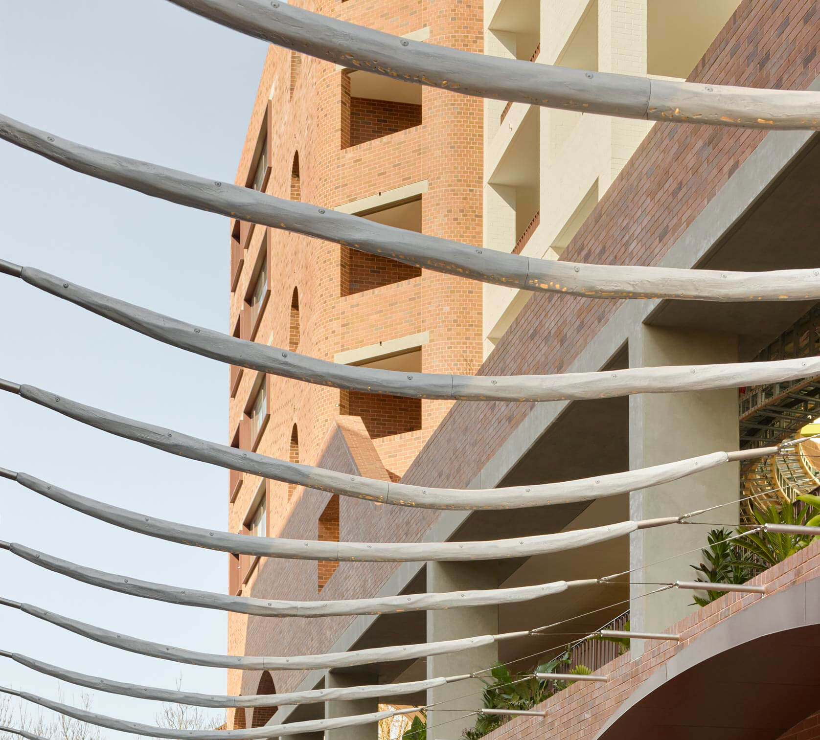 Architectural detail showing curved structural elements and brickwork on a modern residential building.