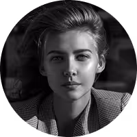 Black and white portrait of a young woman with styled hair wearing a checkered blazer.