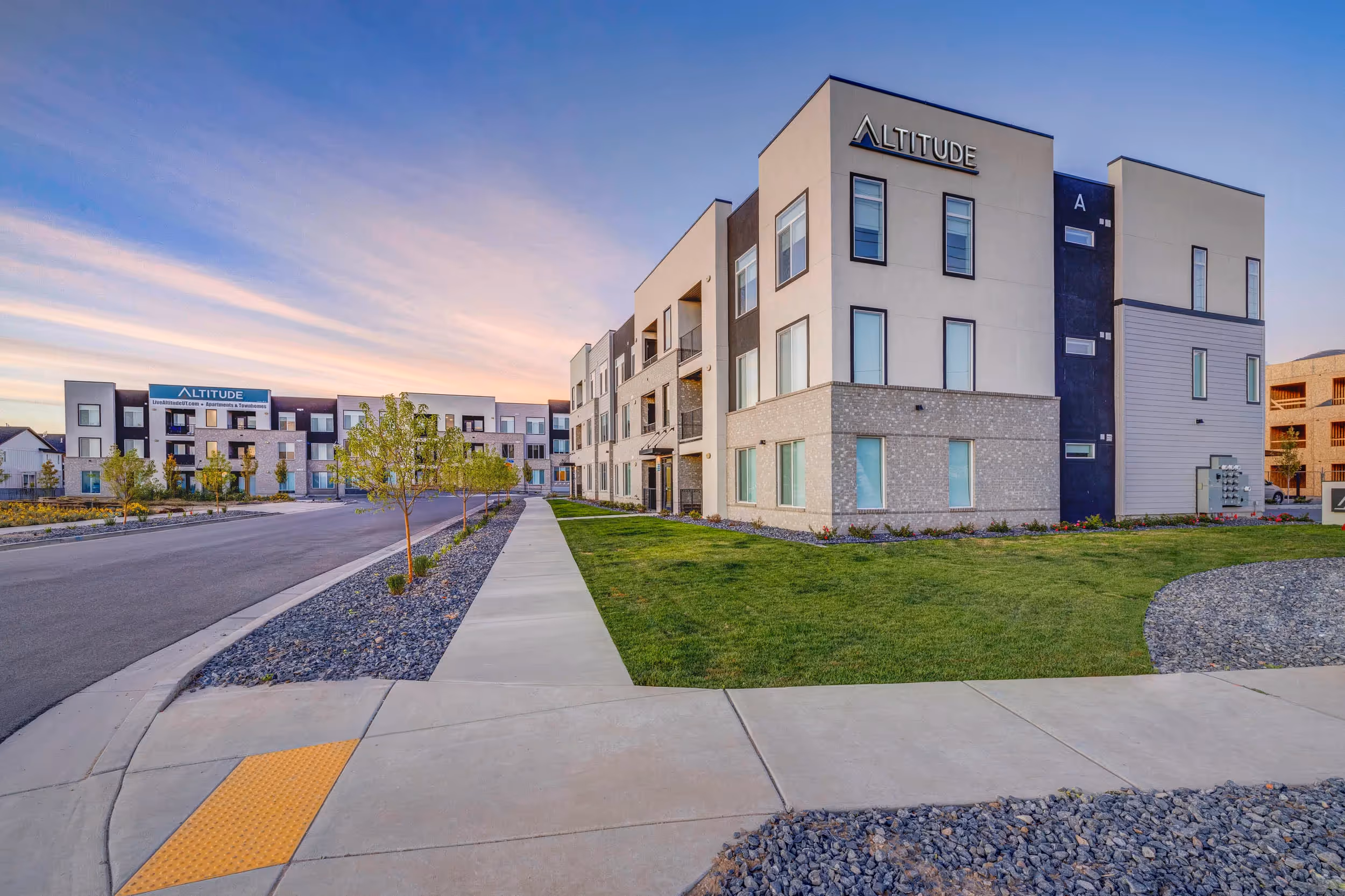 Exterior of apartment building with sidewalk and grass