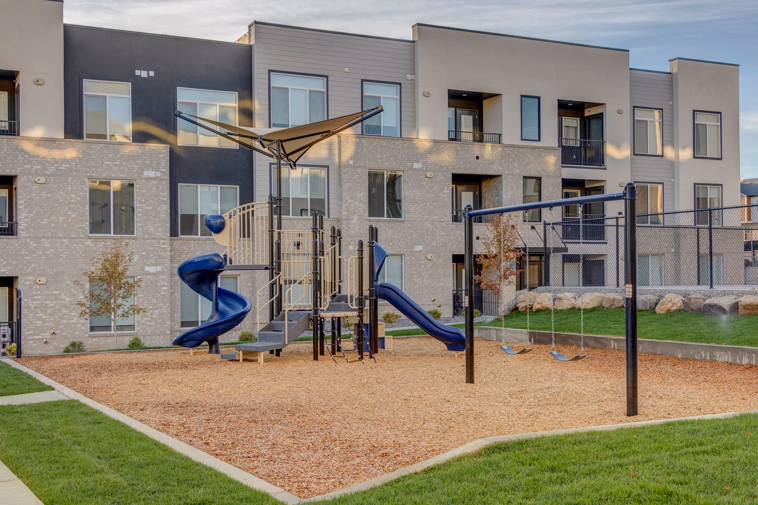 Outdoor park play area with the apartments in the back