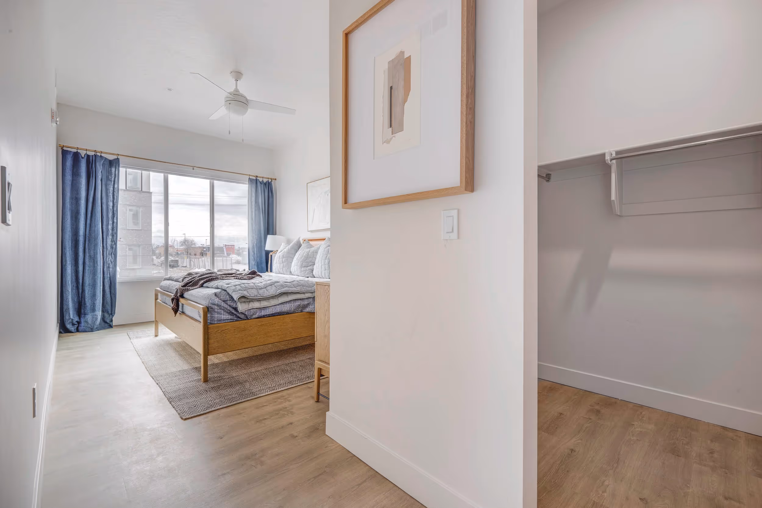 View of walk in closet with bed in the back