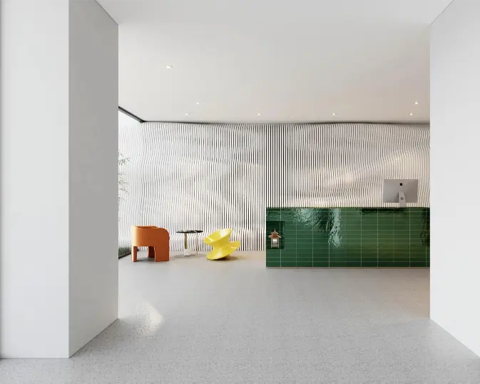 Minimalist modern interior with a green tiled reception desk, orange and yellow chairs, and a textured white wall background.