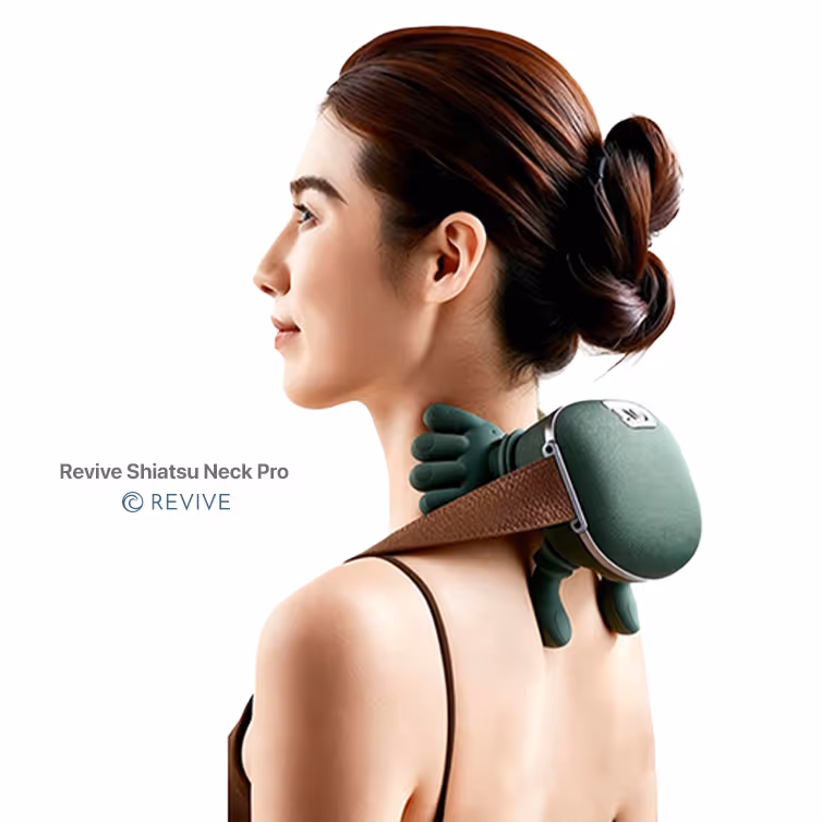 Mujer de perfil usando masajeador de cuello Revive Shiatsu Neck Pro verde con correas marrones.