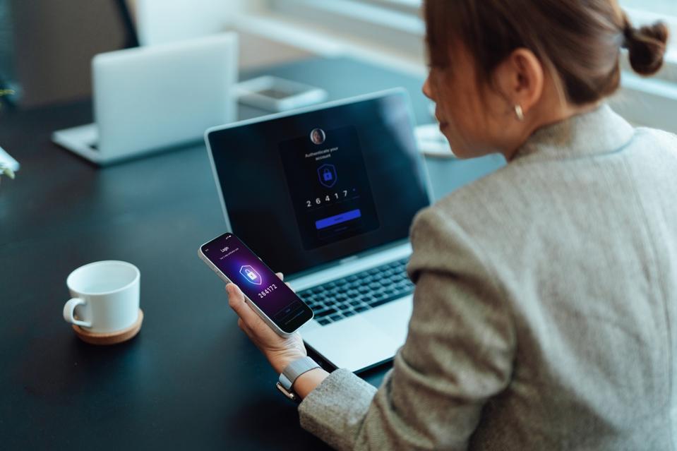 Woman sitting at desk with laptop and phone