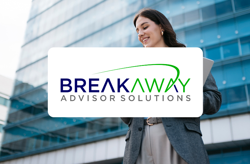 Walking looking at her phone holding a laptop with a building behind her